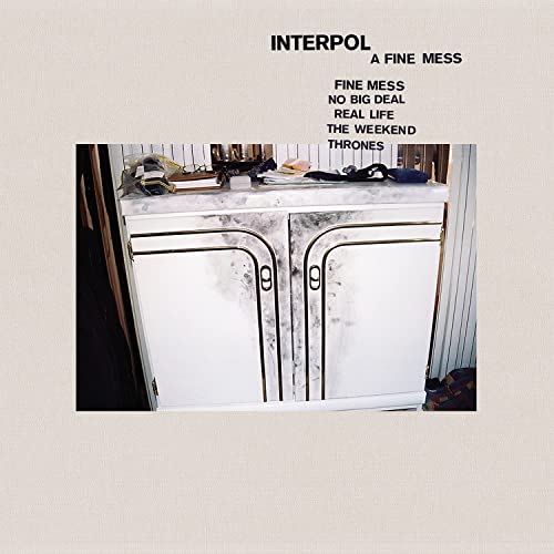Interpol album cover: a white cabinet with objects on top, muted colors.