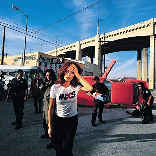Album cover for INXS’s “Elegantly Wasted” featuring a woman and crashed helicopter.