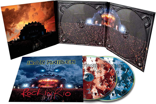 "Album cover with stage, crowd, and giant face looming in cloudy sky."