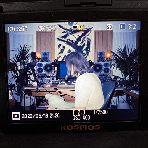 Digital camera screen showing a person sitting at a music studio mixing desk.