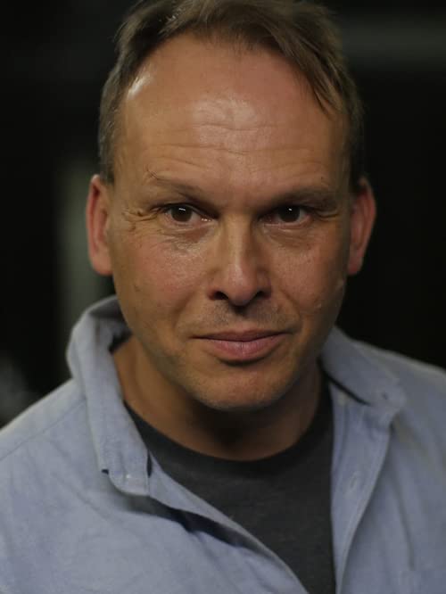 Close-up portrait of a middle-aged man with short blond hair.