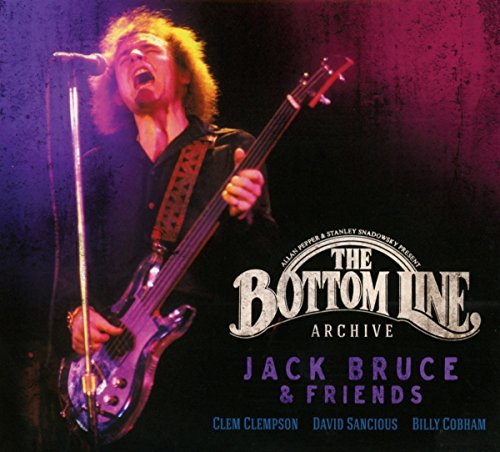 Jack Bruce playing bass guitar on album cover, dark background.