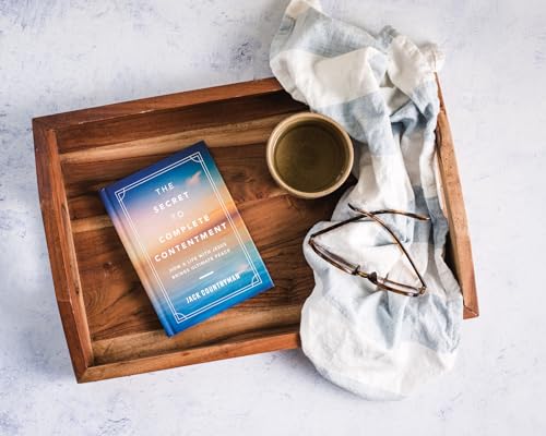 Book titled “The Secret to Complete Contentment” with coffee and glasses.
