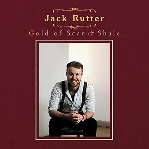 "Album cover with a man sitting, wearing suspenders, on a maroon background."