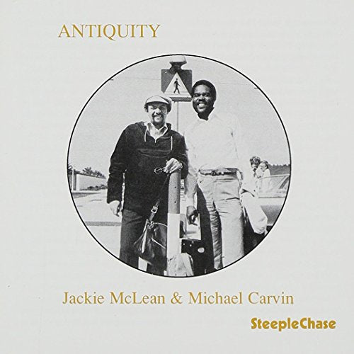 Album cover with a black-and-white photo of two men standing by a car.