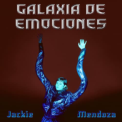 Jackie Mendoza in a metallic blue jacket with arms raised against a dark background.
