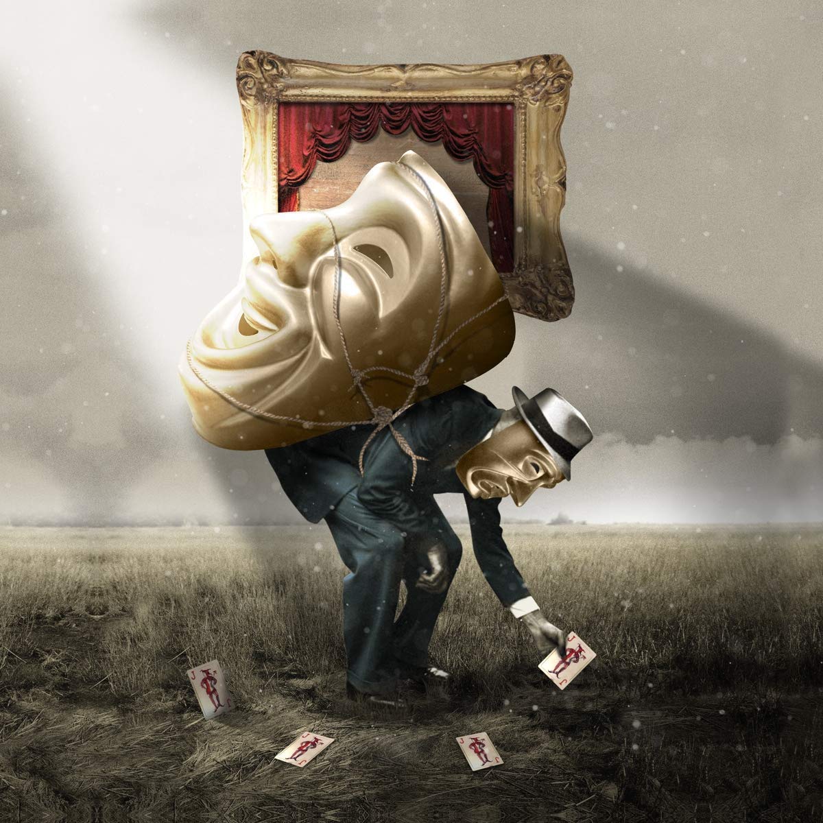"Man in suit with oversized mask and picture frame head in a field."