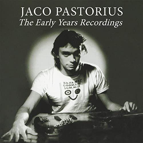 Black and white portrait of Jaco Pastorius with his bass guitar.