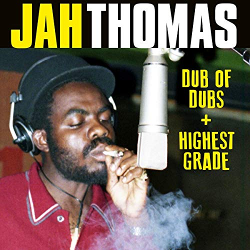Man wearing headphones and smoking in a recording studio with microphone beside him.