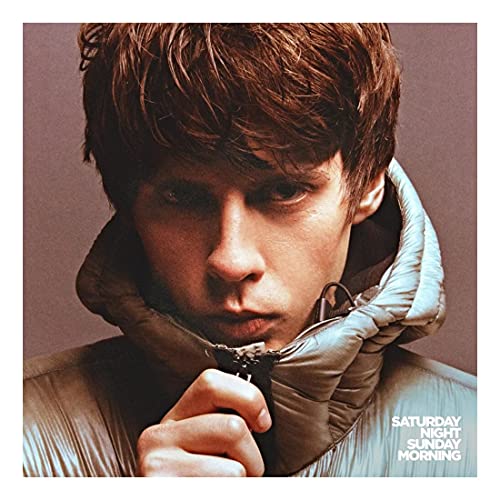 Close-up portrait of Jake Bugg wearing a hooded jacket, album cover.