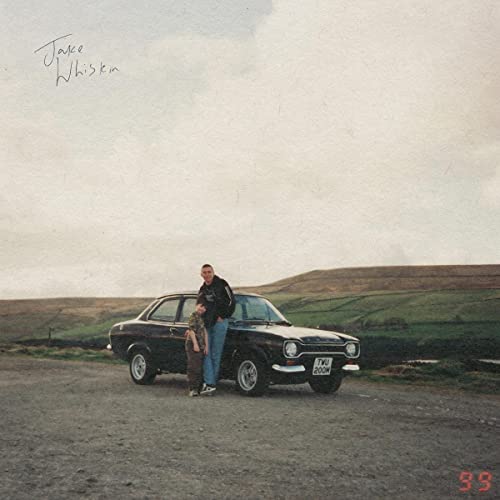 Album cover with a man and woman beside a classic teal car in a field.