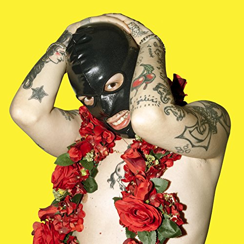 Person with tattoos wearing a black mask and red roses.