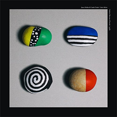 Painted rocks with geometric patterns on a gray background.