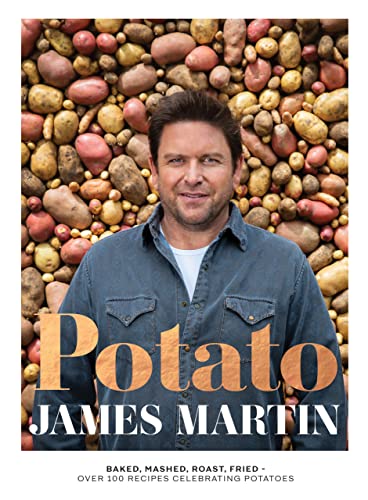 James Martin stands in front of a background of many different types of potatoes.