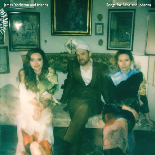 Album cover featuring three people sitting on a couch in a room with paintings.