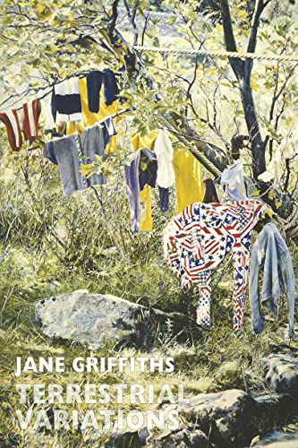 Clothing hangs from a rope between trees in a grassy, sunlit outdoor setting.