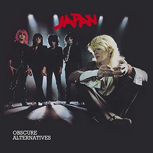 The band Japan poses in dark suits under spotlights on this album cover.