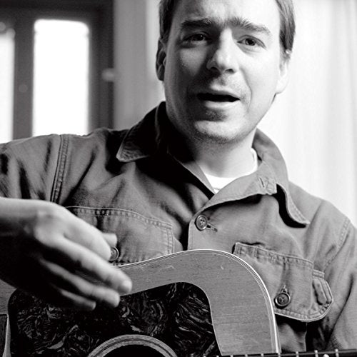 Black and white portrait of Jason Molina with an acoustic guitar.