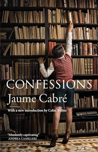 A boy in a sweater vest reaches for a book on a library shelf.