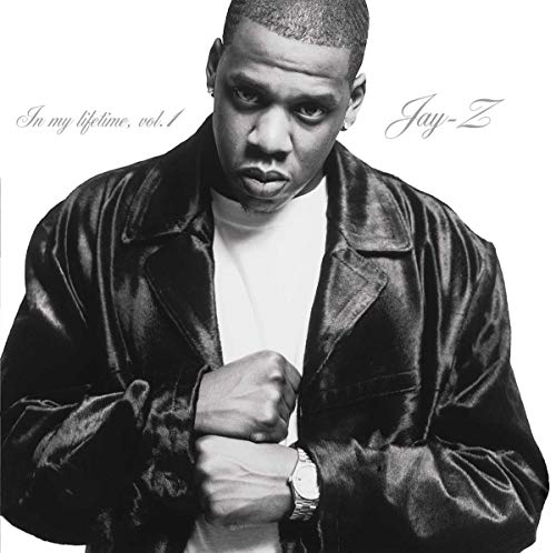 Black and white portrait of Jay-Z wearing a leather jacket against a white background.