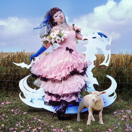 Young woman in pink dress with sheep and swirling white shapes.