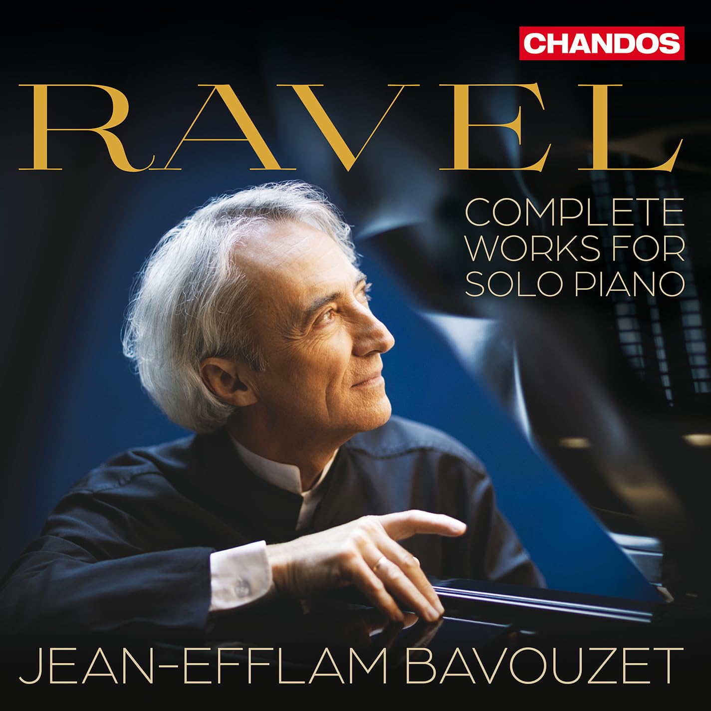 Jean-Efflam Bavouzet sits at a piano on this Ravel complete solo piano works CD cover.