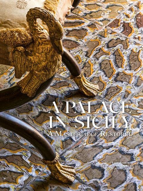 Ornate gold chair detail on a marbled floor, book cover visible.