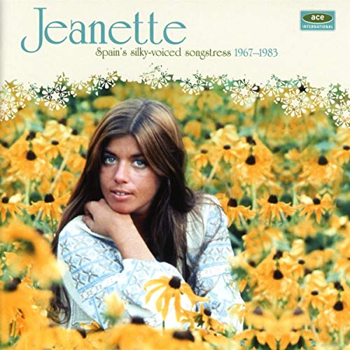 A woman with long brown hair posing in a field of yellow flowers.