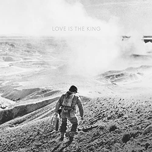 Black and white album cover depicting a figure walking through a desolate landscape.