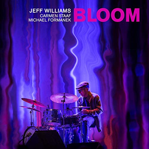 "Album cover with a man playing drums under blue and purple stage lighting."