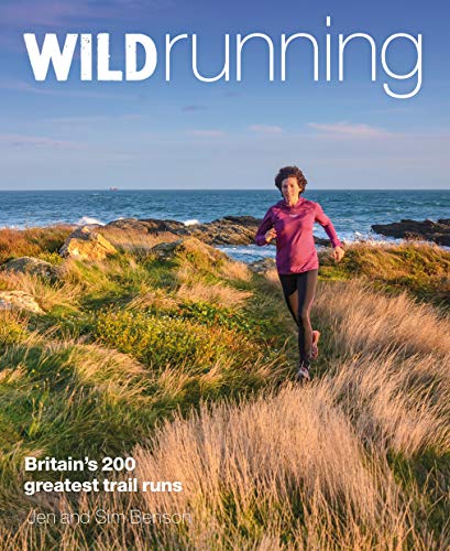 A woman runs along a coastal trail with the ocean in the background.