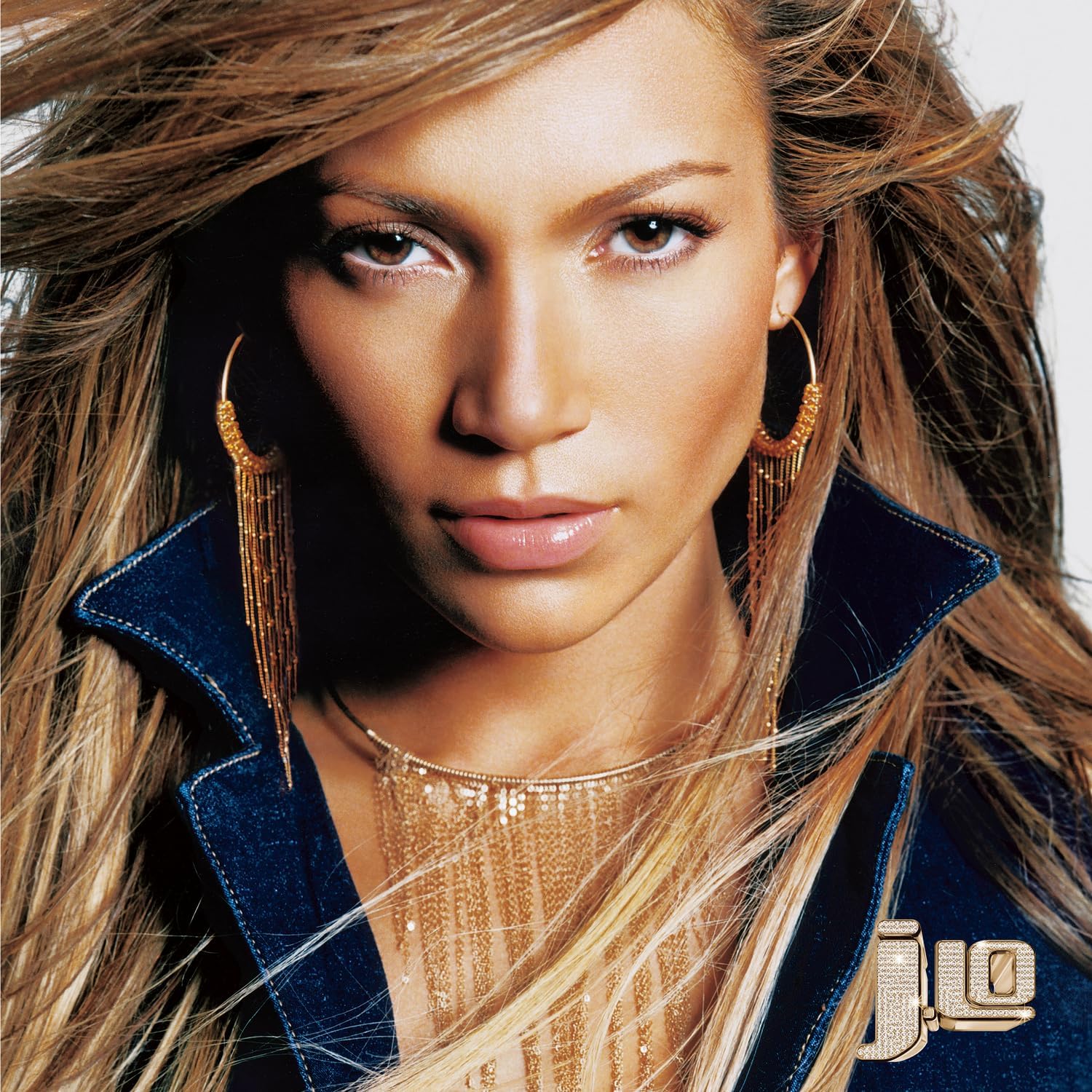 Close-up portrait of Jennifer Lopez with long hair and gold jewelry.