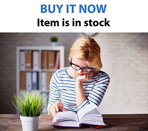 A woman wearing glasses reads a book at a desk with a small plant.