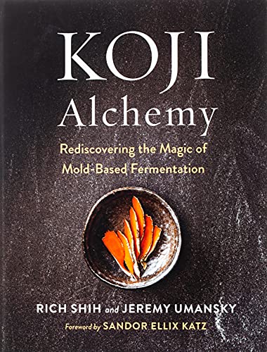 Book cover titled Koji Alchemy featuring a small bowl of orange slices on stone.