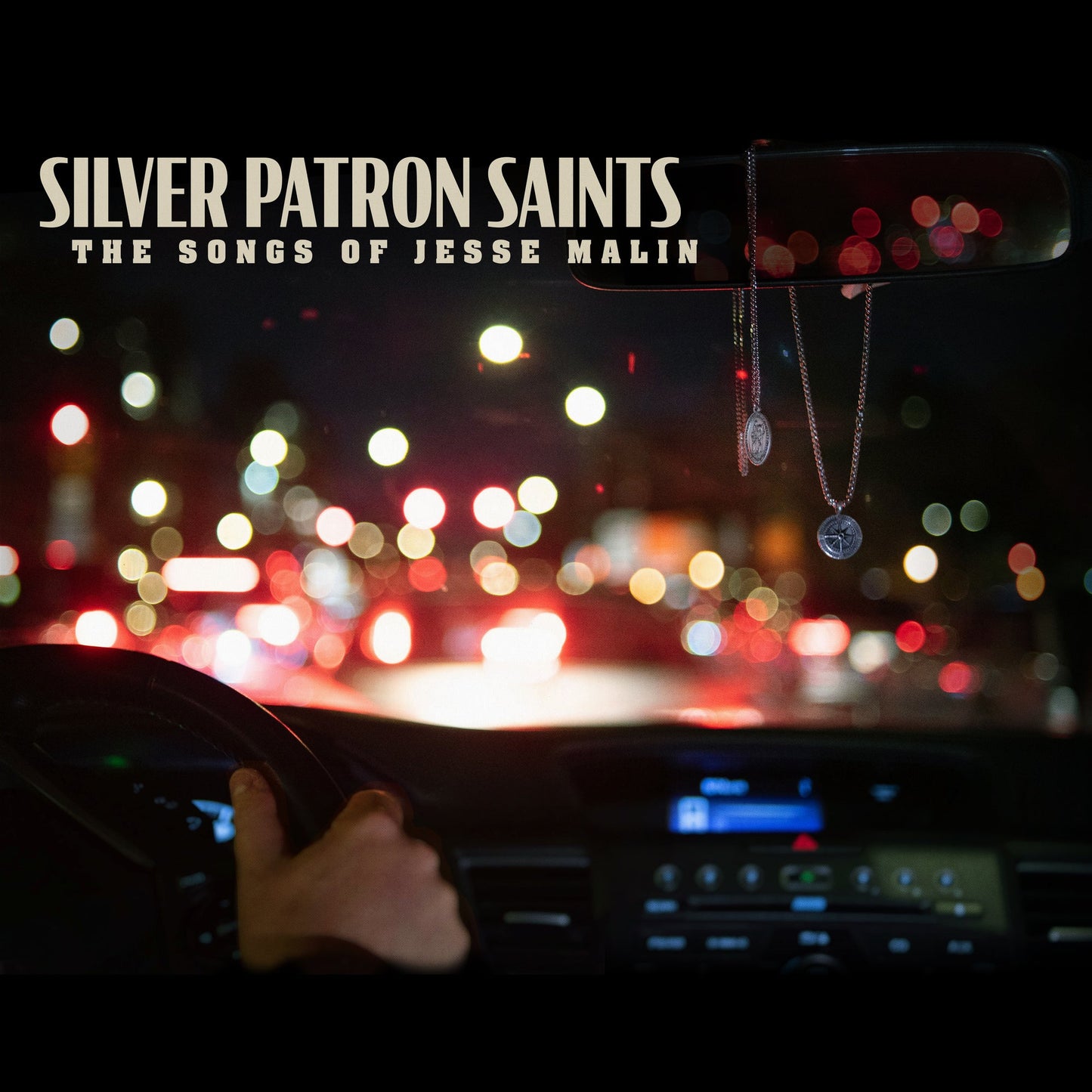 Album cover for Jesse Malin’s “Silver Patron Saints” showing a car dashboard view.