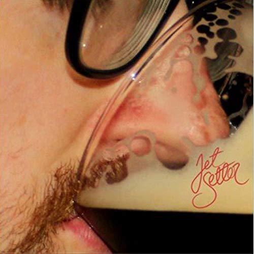 Close-up of a face seen through distorted, reflective sunglasses.