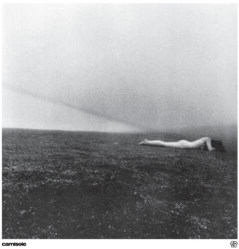 Black and white album cover with a figure lying in a field.