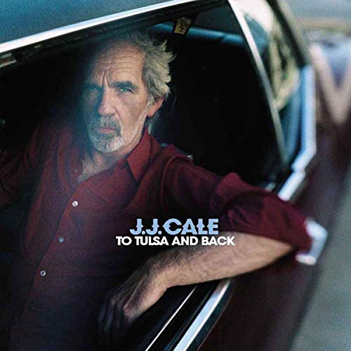 J.J. Cale in a maroon shirt sitting in a car, album cover art.