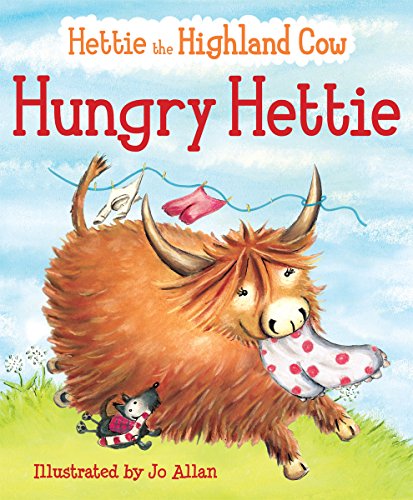 Brown Highland cow with horns eating laundry on a green field.