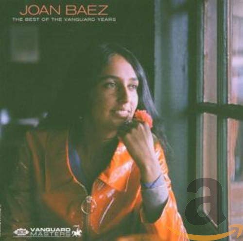 Joan Baez wearing an orange jacket, resting her chin on her hand by a window.