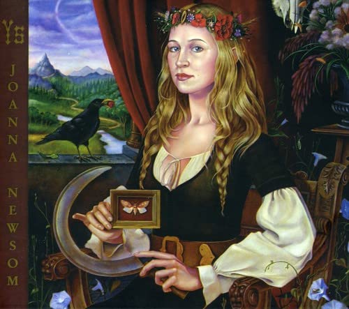 A woman with blonde hair and a flower crown holds a framed moth painting.