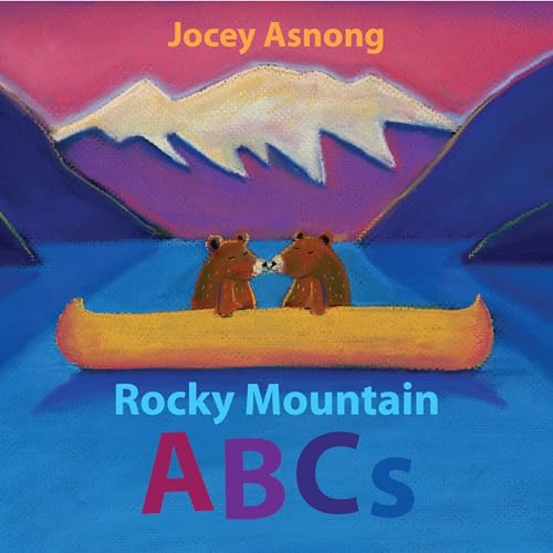 Two bear cubs in a canoe with mountains in the background.