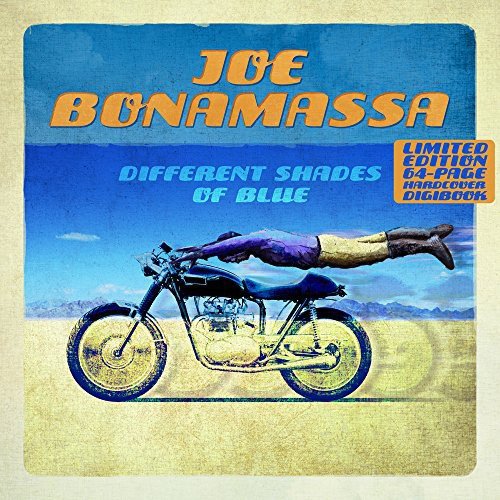"CD album cover with man lying on motorcycle, blue sky, and sandy ground."