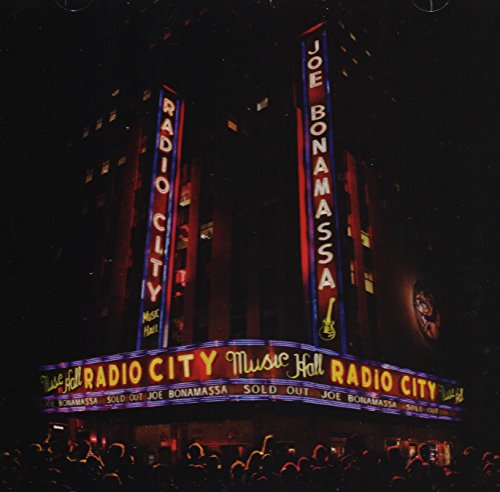 Radio City Music Hall at night with illuminated signs reading Joe Bonamassa.
