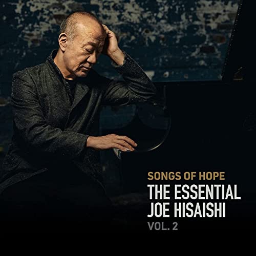Joe Hisaishi album cover featuring the composer with a piano, dark background.