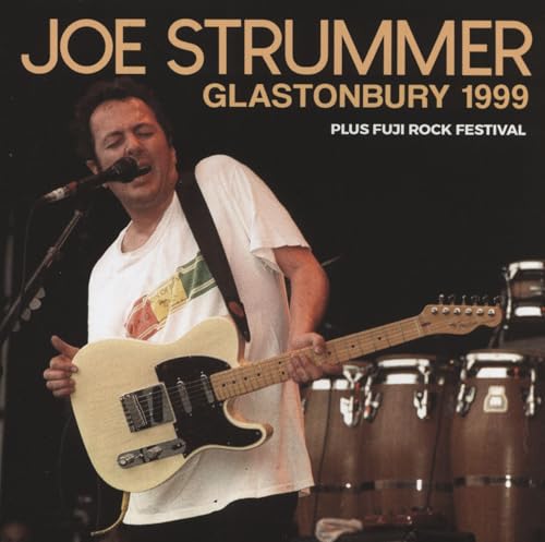 Joe Strummer playing guitar with a microphone at Glastonbury 1999.