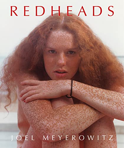 Book cover: close-up portrait of a freckled redhead embracing herself.