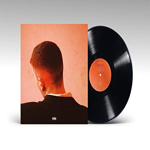 Vinyl record and album cover featuring the back of a man’s head.