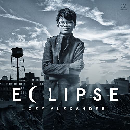 Joey Alexander album cover, “Eclipse,” featuring a young man and cityscape.