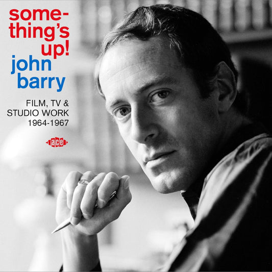 Black and white portrait of John Barry holding a pen with album text overlay.